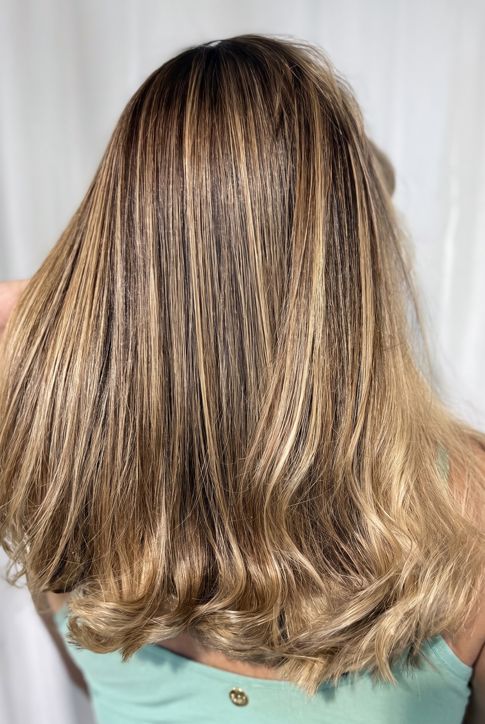 Cabelo médio com iluminação dourada e acabamento polido